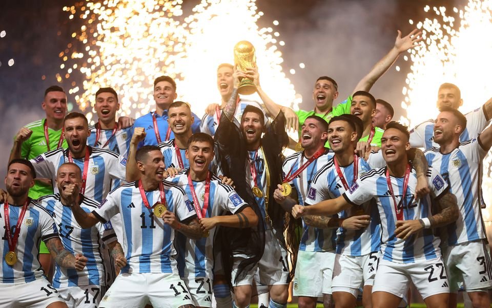 Argentina's Lionel Messi celebrates with the trophy and teammates after winning the World Cup 