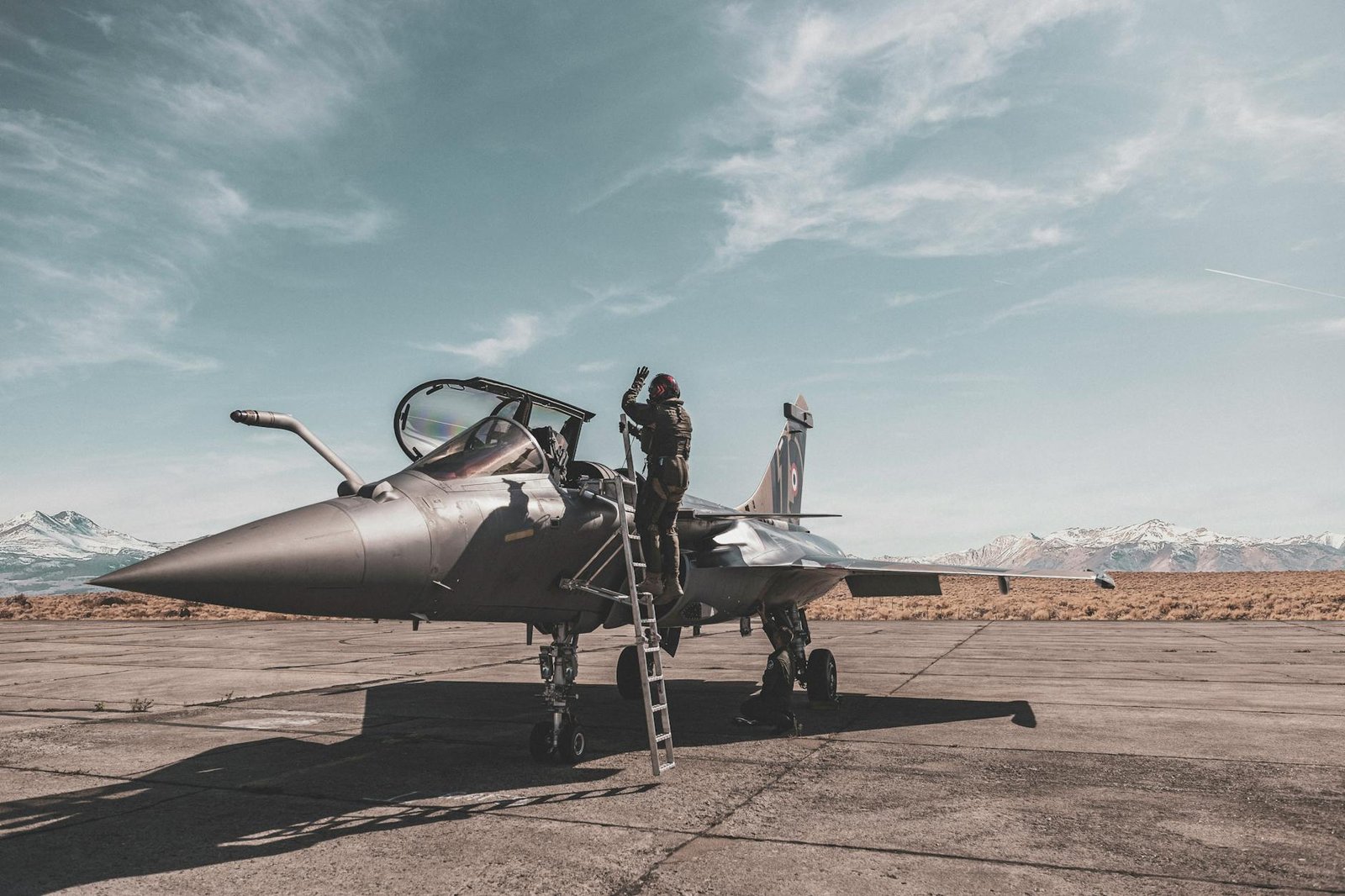 photo of person standing beside fighter jet