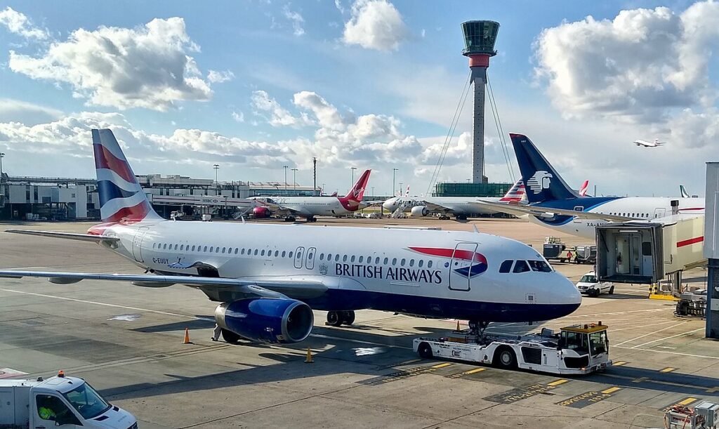 G-EUUY- British Airways A320 on stand at London Heathrow with Control tower in the background used for air traffic control.